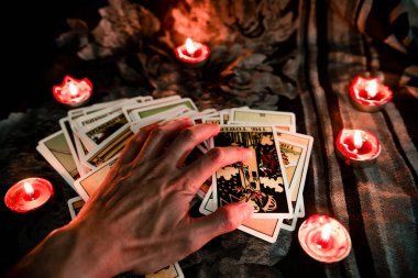 Karanlık arka planda mum ışığı olan tarot kartı.