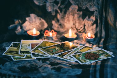 Astro 'nun karanlık arka planında mum ışığı olan tarot kartı.