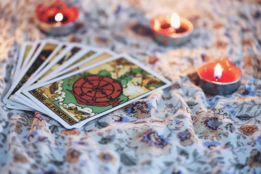 Astro 'nun karanlık arka planında mum ışığı olan tarot kartı.