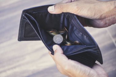 Cüzdan ve borç yönetimi kavramındaki madeni para / Emeklilik kavramındaki yoksul yaşlı bir adamın elinde boş cüzdan