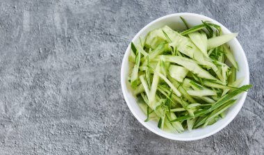 Beyaz kasede salatalık dilimi, üst görünüm, salata veya yemek pişirmek için dilimlenmiş salatalık. 