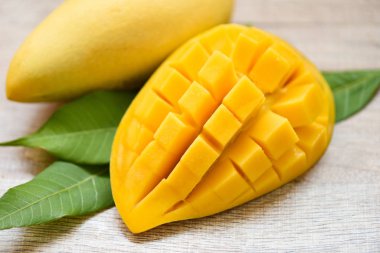 Mango dilimi ve mango yaprakları tropikal yaz meyvesi kavramından / Tatlı olgun mangoların yarısını kes