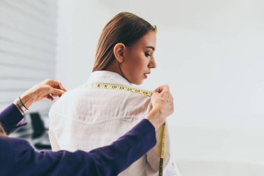 Fashion designer studio measuring textile material scissors cutting fabric by woman designer stylish showroom / designer working professional measuring a clothing for tailoring model woman in workshop
