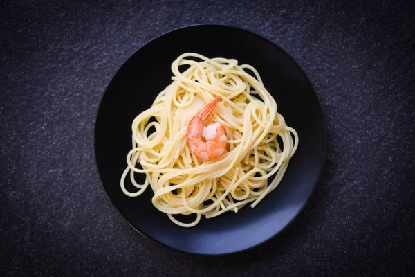 Spaghetti italian pasta with shrimp prawn served on plate black background / italian food and menu concept spaghetti seafood