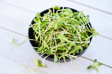 Sunflower seedling concept / Green young sunflower sprouts on bowl for cooked food healthy vegetables
