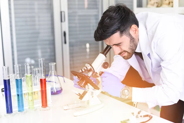 Male Scientists or Doctor in lab biochemistry genetics forensics microbiology and test tube / Scientist research working together conduct experiments and looks on microscope in modern laboratory