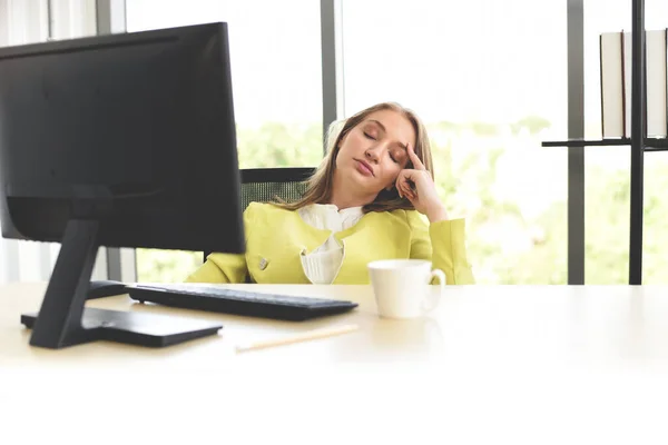 Business woman suffering stress working computer and a cup of coffee on the table / Stressed woman tired with headache at office feeling sick at work concept