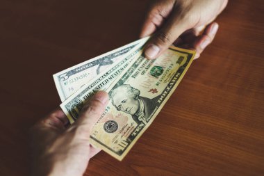 Business man give money bribe concept / person hands man giving money on wooden table background pay cash on delivery pay to receive money 