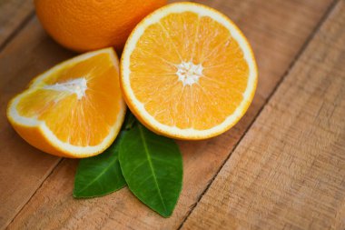 Fresh orange slice half and orange leaf healthy fruits harvest concept / Orange fruit on wooden background