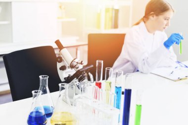Young female scientist doing some research working conduct experiments and microscope in modern laboratory / Scientists in lab biochemistry genetics forensics microbiology and test tube female doctor