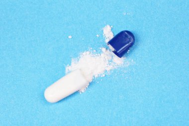 Mavi arka plan üzerindeki kapsül hapı / Açık ilaç hapları kapsül uyuşturucu konseptini soy