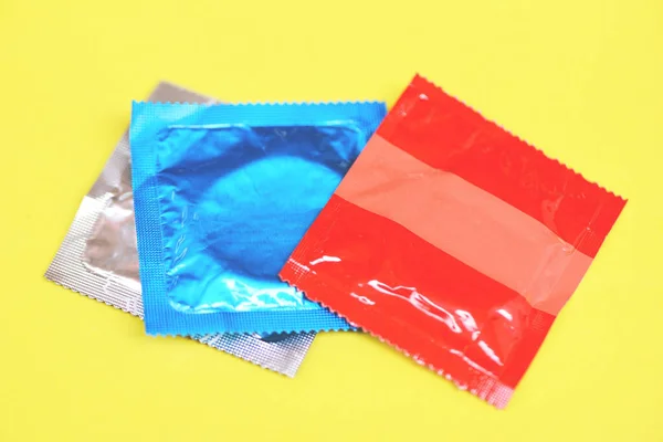 Kondom Yang Diisolasi Pada Latar Belakang Kuning Bungkus Kondom Berwarna — Stok Foto