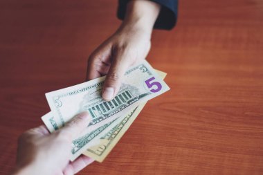 Business man give money bribe concept / person hands man giving money on wooden table background pay cash on delivery pay to receive money  