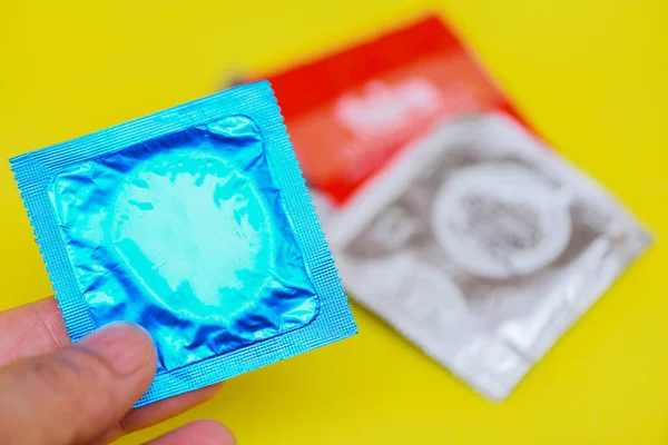 Preservativo Mão Segurar Fundo Amarelo Pacote Preservativo Colorido Para Contraceptivo — Fotografia de Stock