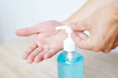Kadınlar ellerini alkol jeliyle veya antibakteriyel sabun dezenfektanıyla yıkıyor / Bir şişe antibakteriyel dezenfektan kullanan insanlar Covid-19 Coronavirus kavramının temiz el hijyen önlemini ovuyorlar