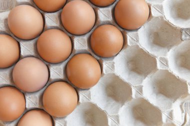 Yumurta kutusundaki yumurtalar ahşap arka planda üst görünümde / Çiğ tavuk yumurtalarını kapat organik gıda, seçici odaklanma