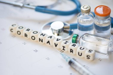 COVID-19 Coronavirus için şırınga enjeksiyonlu ilaç aşısı ve takvim / aşı şişesinde steteskop grip salgınını önleme amaçlı grip salgını