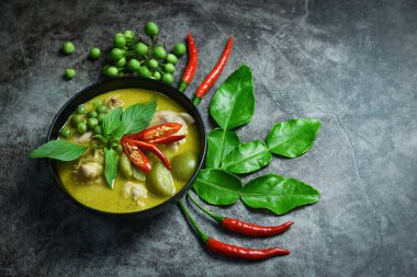 Çorba kasesinde yeşil köri, siyah tabakta sebze, masada yeşil körili tavuk, Asya mutfağı. 