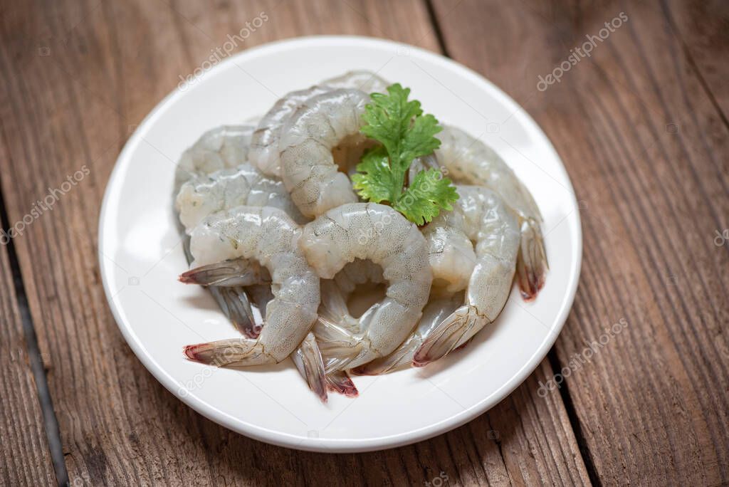 raw shrimp on white plate and wooden background for cooking / close up fresh shrimps or prawns , Seafood shelfish