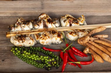 Baharatlı ızgara kurbağa grubu ahşap arka planda izole edilmiş.