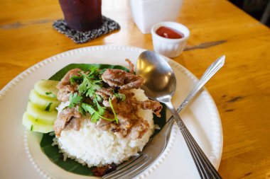 Tahta bir masada domuz eti ile kızarmış pilav