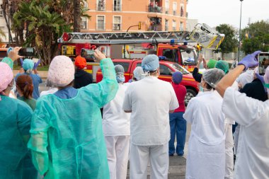Malaga, İspanya. 11 Nisan 2020. Mlaga 'lı Carlos Haya hastanesinin sağlık personeline polis, sivil ve itfaiye teşkilatından Covid-19 haraçları..