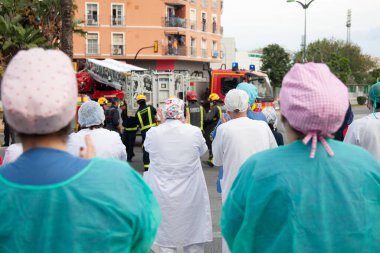 Malaga, İspanya. 11 Nisan 2020. Mlaga 'lı Carlos Haya hastanesinin sağlık personeline polis, sivil ve itfaiye teşkilatından Covid-19 haraçları..