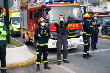 Malaga, İspanya. 11 Nisan 2020. Mlaga 'lı Carlos Haya hastanesinin sağlık personeline polis, sivil ve itfaiye teşkilatından Covid-19 haraçları..
