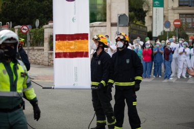 Malaga, İspanya. 11 Nisan 2020. Mlaga 'lı Carlos Haya hastanesinin sağlık personeline polis, sivil ve itfaiye teşkilatından Covid-19 haraçları..