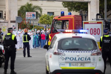 Malaga, İspanya. 11 Nisan 2020. Mlaga 'lı Carlos Haya hastanesinin sağlık personeline polis, sivil ve itfaiye teşkilatından Covid-19 haraçları..