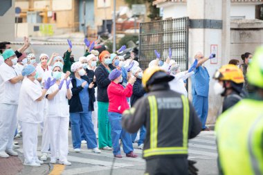 Malaga, İspanya. 11 Nisan 2020. Mlaga 'lı Carlos Haya hastanesinin sağlık personeline polis, sivil ve itfaiye teşkilatından Covid-19 haraçları..