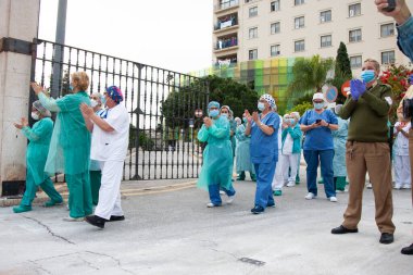 Malaga, İspanya. 16 Nisan 2020. Yerel polis ve itfaiyecilerden Malaga 'lı Carlos Haya hastanesinin sağlık personelini alkışlıyoruz. Coronavirus' a karşı savaşan itfaiyeciler..