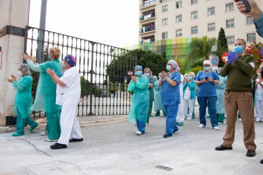 Malaga, İspanya. 16 Nisan 2020. Yerel polis ve itfaiyecilerden Malaga 'lı Carlos Haya hastanesinin sağlık personelini alkışlıyoruz. Coronavirus' a karşı savaşan itfaiyeciler..