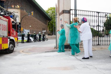 Malaga, İspanya. 16 Nisan 2020. Yerel polis ve itfaiyecilerden Malaga 'lı Carlos Haya hastanesinin sağlık personelini alkışlıyoruz. Coronavirus' a karşı savaşan itfaiyeciler..