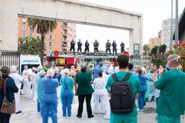 Malaga, İspanya. 16 Nisan 2020. Yerel polis ve itfaiyecilerden Malaga 'lı Carlos Haya hastanesinin sağlık personelini alkışlıyoruz. Coronavirus' a karşı savaşan itfaiyeciler..