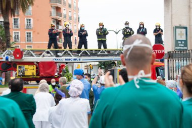 Malaga, İspanya. 16 Nisan 2020. Yerel polis ve itfaiyecilerden Malaga 'lı Carlos Haya hastanesinin sağlık personelini alkışlıyoruz. Coronavirus' a karşı savaşan itfaiyeciler..