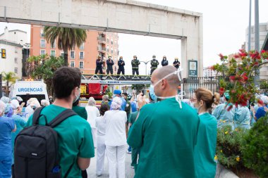 Malaga, İspanya. 16 Nisan 2020. Yerel polis ve itfaiyecilerden Malaga 'lı Carlos Haya hastanesinin sağlık personelini alkışlıyoruz. Coronavirus' a karşı savaşan itfaiyeciler..