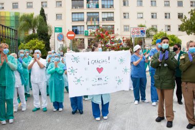 Malaga, İspanya. 16 Nisan 2020. Yerel polis ve itfaiyecilerden Malaga 'lı Carlos Haya hastanesinin sağlık personelini alkışlıyoruz. Coronavirus' a karşı savaşan itfaiyeciler..