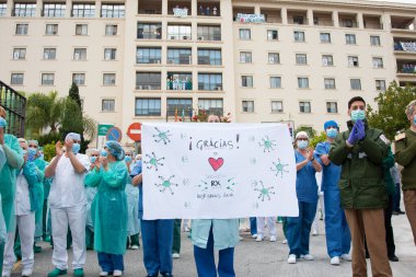 Malaga, İspanya. 16 Nisan 2020. Yerel polis ve itfaiyecilerden Malaga 'lı Carlos Haya hastanesinin sağlık personelini alkışlıyoruz. Coronavirus' a karşı savaşan itfaiyeciler..
