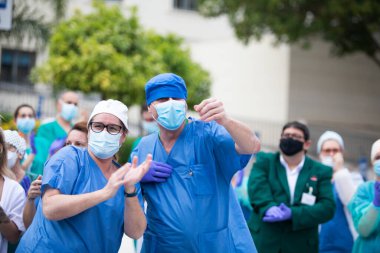 Mlaga, İspanya. 16 Nisan 2020. Covid-19 Haraç Töreni, yerel polis ve itfaiyecilerden Mlaga Hastanesi 'nin sağlık personeli Carlos Haya' yı alkışlıyor. Coronavirus 'a karşı dövüşçüler..