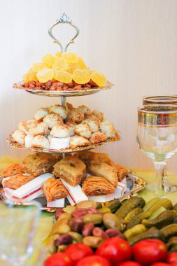 Oriental şekerlerle dolu katmanlı bir tabak. Şeker, baklava, marmelat ve diğer tatlılar..