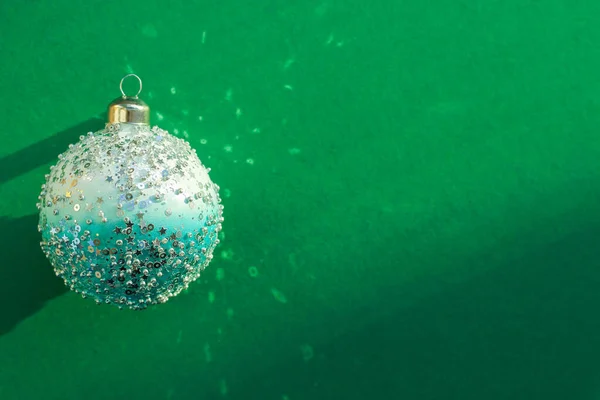 Niebieska świąteczna piłka na zielonym tle — Zdjęcie stockowe