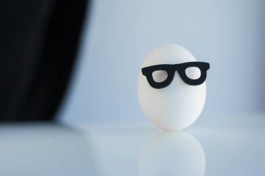 Siyah çerçeveli gözlüklü bir beyaz yumurta siyah ve beyaz arka planda