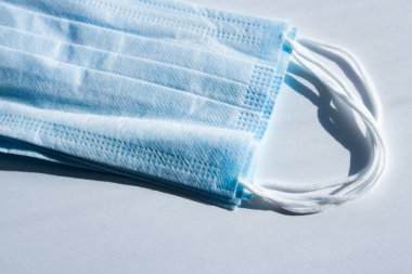 Koronavirüse karşı korunmak için antiviral tıbbi maske. Cerrahi koruyucu maske. Beyaz arka planda tıbbi solunum bandajı var. Virüs ve salgın COVID-19 'un yayılmasının önlenmesi