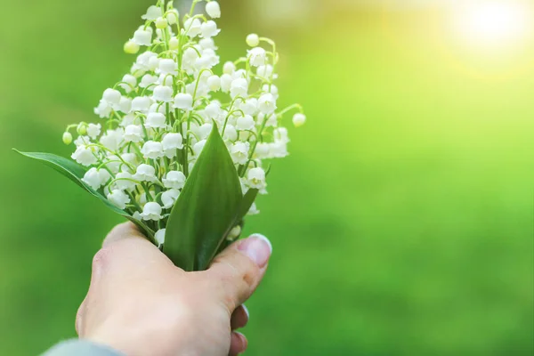 Bouquet of lilies of the valley in hands of girl. Romantic date. The concept of spring, may, summer