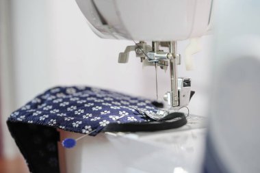 Kadın el yapımı el işi projeleri maske takıyor. Corona virüsü koruması için ev yapımı tıbbi maske. Evde Covid-19 yüz maskesi dikiyorum..