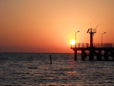 Yazın iskelede portakal rengi gün batımı.