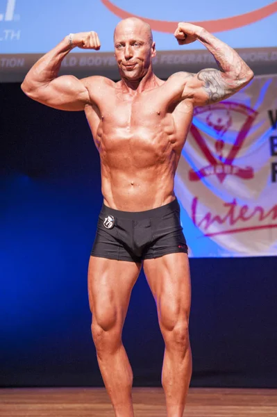 Male bodybuilder shows his best at championship on stage — Stock Photo, Image