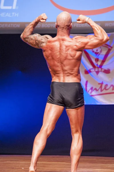 Männlicher Bodybuilder zeigt sich bei Meisterschaft auf der Bühne von seiner besten Seite — Stockfoto