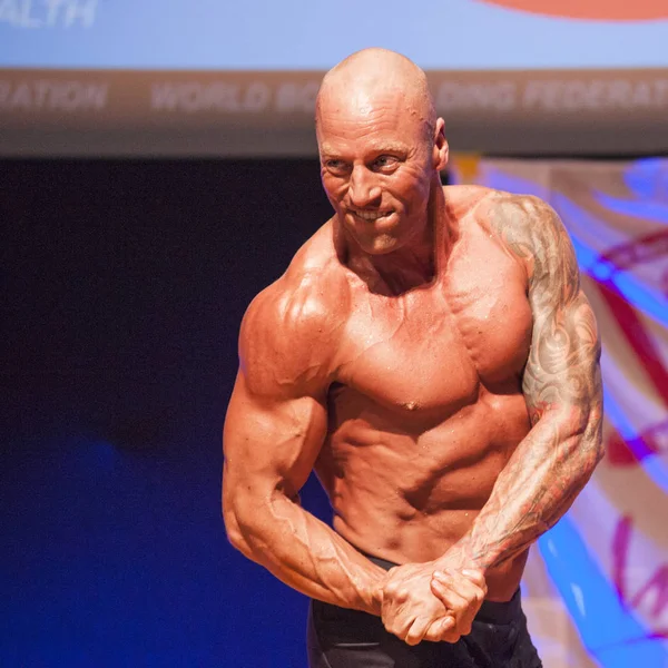 Male bodybuilder shows his best at championship on stage — Stock Photo, Image